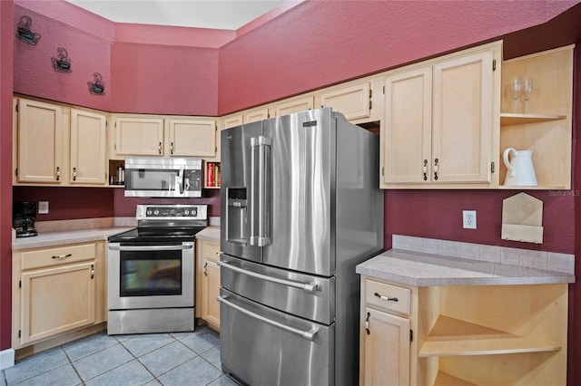 kitchen featuring light tile patterned floors, light brown cabinets, and stainless steel appliances