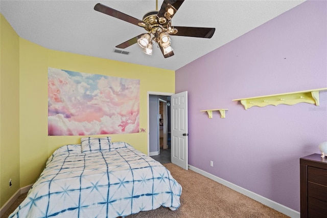 carpeted bedroom featuring ceiling fan and a textured ceiling