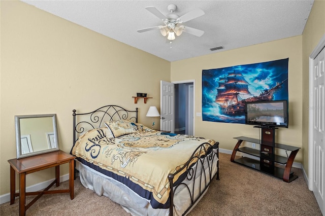 bedroom featuring carpet flooring, a textured ceiling, a closet, and ceiling fan