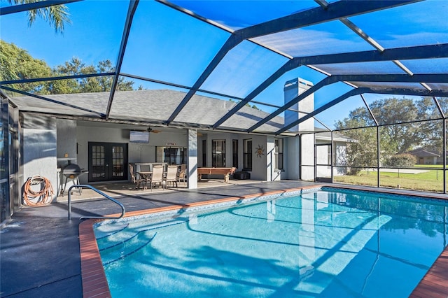 view of swimming pool featuring glass enclosure, ceiling fan, french doors, grilling area, and a patio