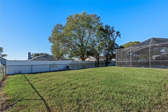 view of yard with glass enclosure