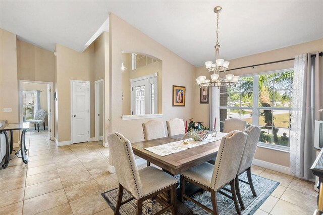 dining room with light tile patterned flooring, high vaulted ceiling, and a chandelier