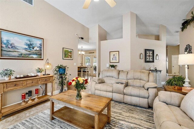 tiled living room featuring ceiling fan with notable chandelier and a towering ceiling