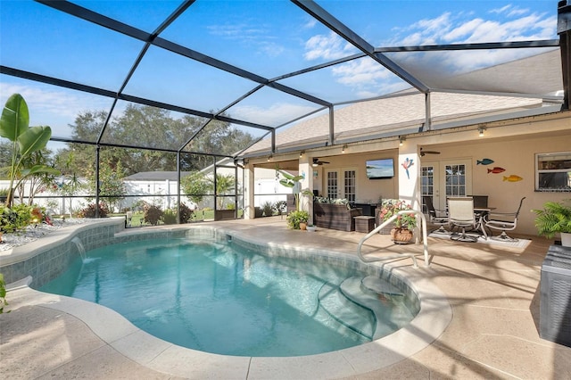 view of swimming pool featuring french doors, ceiling fan, a lanai, and a patio area