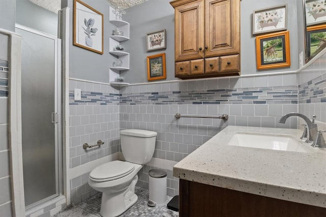 bathroom featuring vanity, tile patterned floors, toilet, tile walls, and a shower with shower door