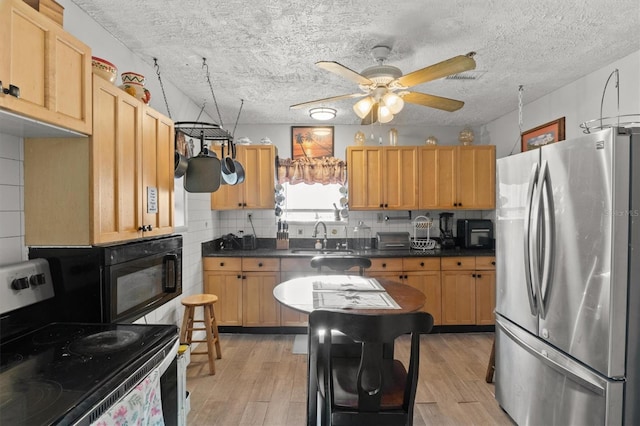 kitchen featuring electric range, sink, backsplash, stainless steel fridge, and light hardwood / wood-style floors