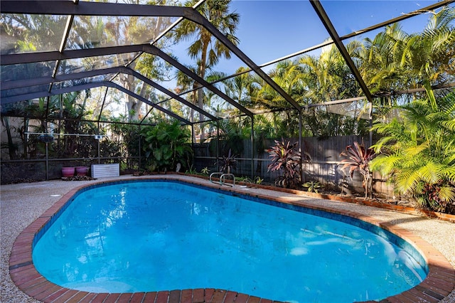 view of swimming pool featuring glass enclosure