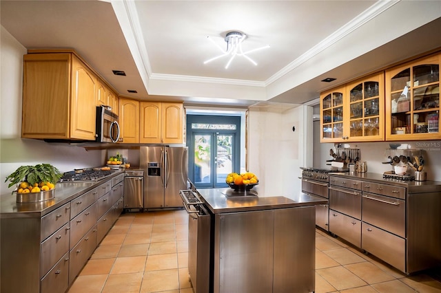 kitchen with french doors, a center island, stainless steel appliances, a raised ceiling, and light tile patterned flooring