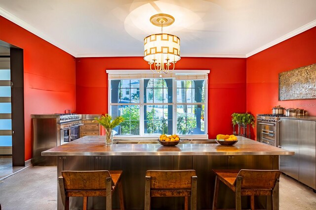 kitchen with ornamental molding, light colored carpet, stainless steel counters, decorative light fixtures, and a notable chandelier