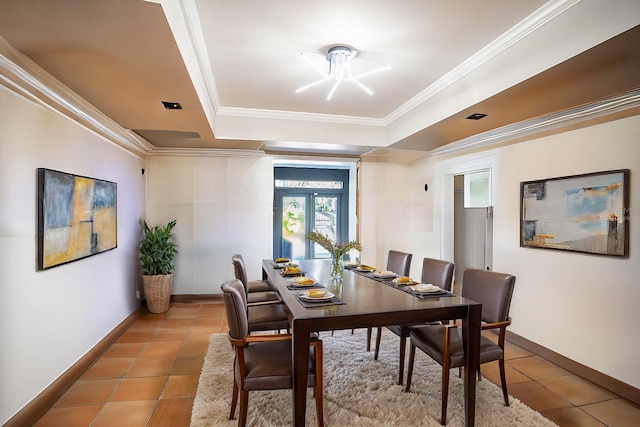 dining area with tile patterned floors, a raised ceiling, crown molding, and french doors