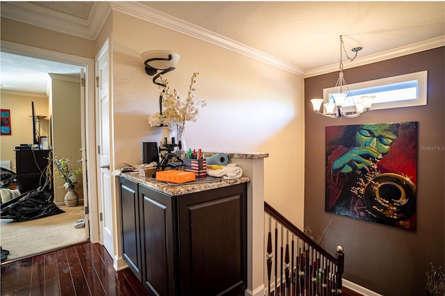 bar featuring dark brown cabinetry, dark wood-type flooring, hanging light fixtures, and ornamental molding