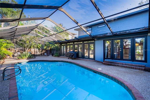 view of pool featuring glass enclosure and a grill