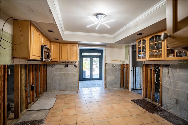 kitchen with crown molding, a tray ceiling, and french doors