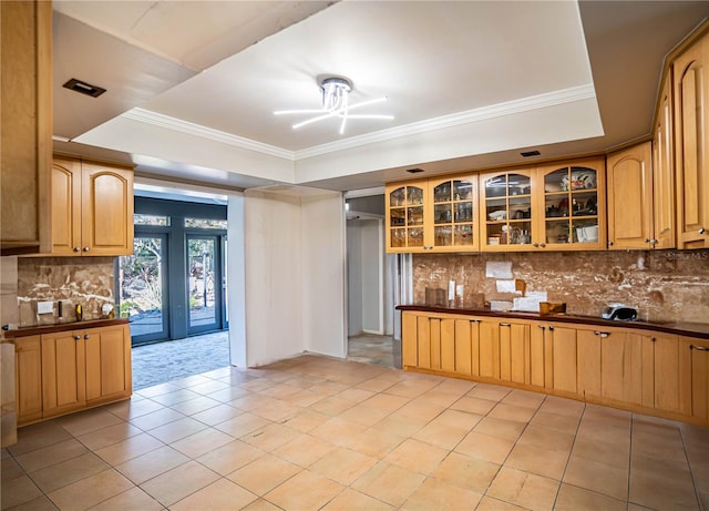 kitchen with decorative backsplash, light brown cabinets, and a tray ceiling