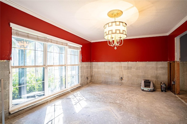 unfurnished dining area with ornamental molding, tile walls, and a notable chandelier