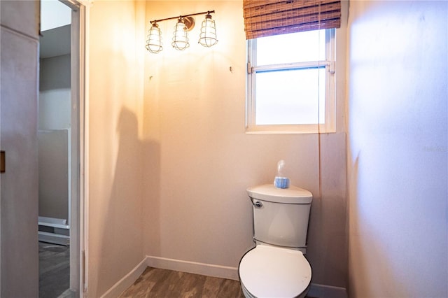 bathroom featuring wood-type flooring and toilet