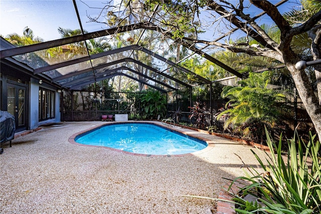 view of pool featuring glass enclosure and a patio