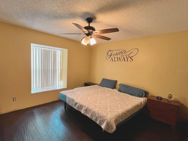 bedroom with a textured ceiling, ceiling fan, and dark hardwood / wood-style floors