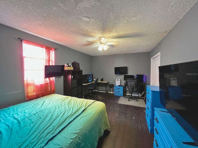 bedroom with a textured ceiling, dark hardwood / wood-style floors, and ceiling fan