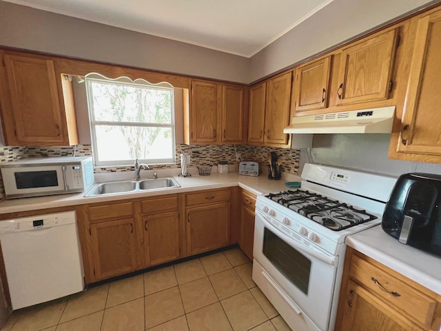 kitchen featuring decorative backsplash, white appliances, sink, and light tile patterned floors