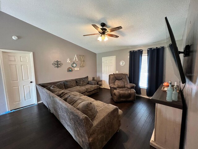 living room featuring dark hardwood / wood-style floors, ceiling fan, and a textured ceiling