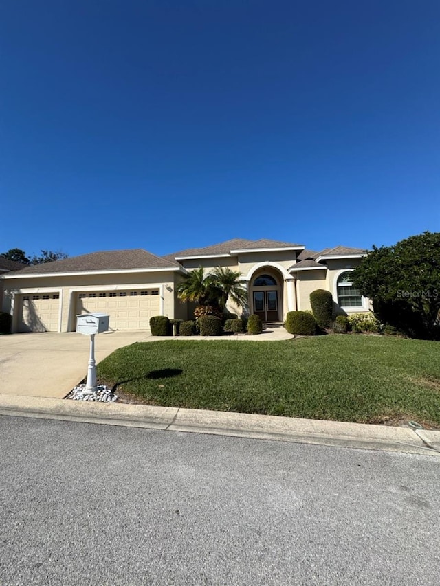 single story home featuring a front yard and a garage