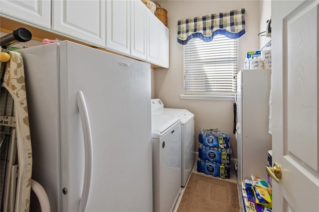 clothes washing area with cabinets and washer and dryer