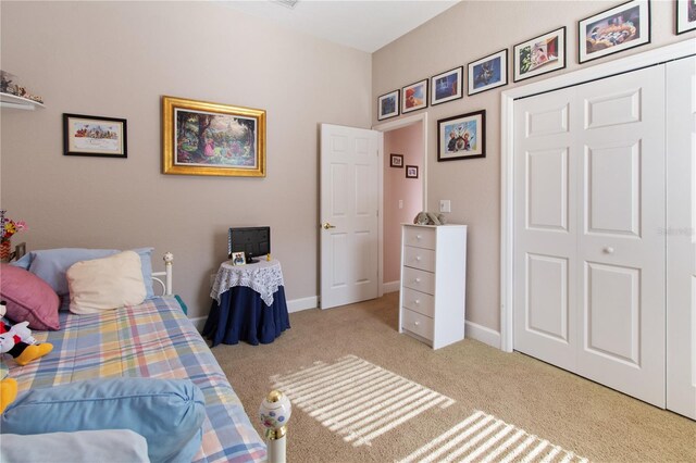 bedroom featuring light colored carpet and a closet