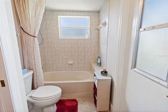 bathroom featuring tile patterned flooring, shower / tub combo, and toilet