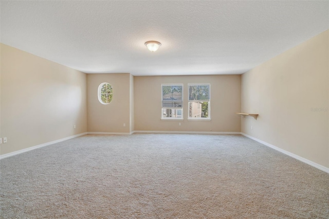 carpeted empty room featuring a textured ceiling