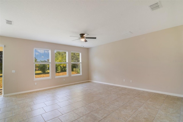 tiled empty room featuring ceiling fan