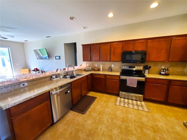 kitchen featuring sink, ceiling fan, appliances with stainless steel finishes, light stone counters, and kitchen peninsula