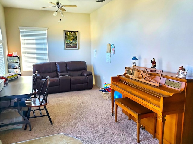 carpeted living room with ceiling fan