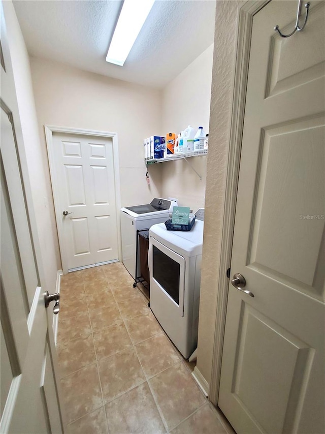 washroom with independent washer and dryer and light tile patterned floors