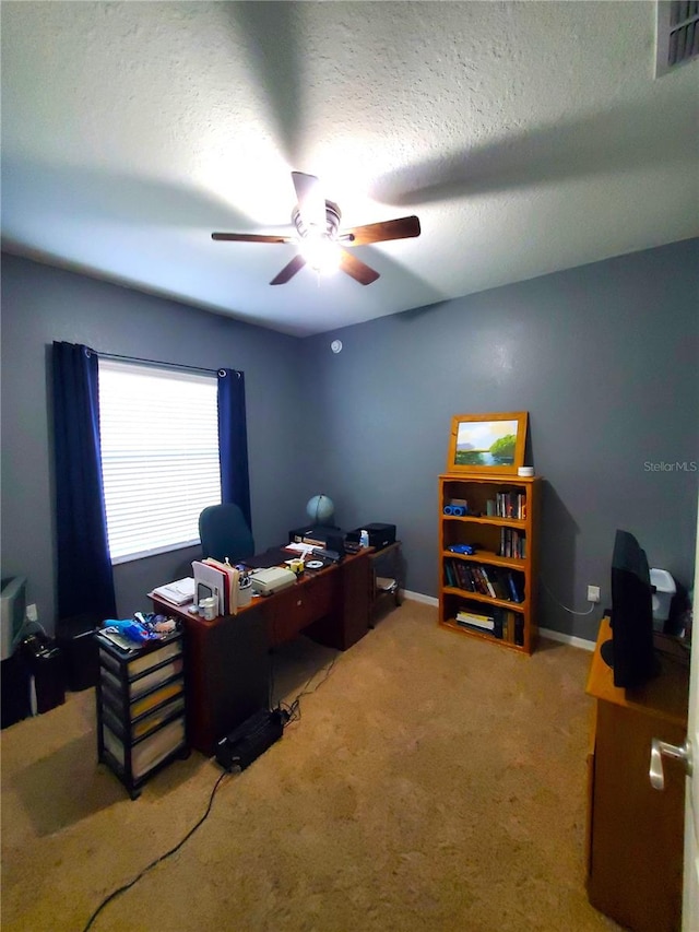 carpeted office space with ceiling fan and a textured ceiling