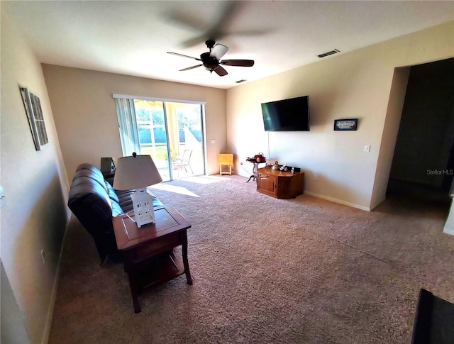 carpeted living room with ceiling fan