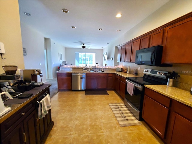 kitchen featuring kitchen peninsula, light stone counters, stainless steel appliances, ceiling fan, and sink