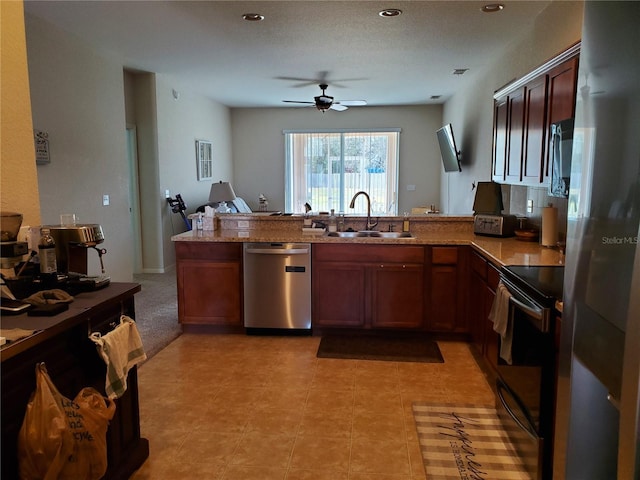 kitchen featuring sink, light tile patterned floors, ceiling fan, kitchen peninsula, and stainless steel appliances