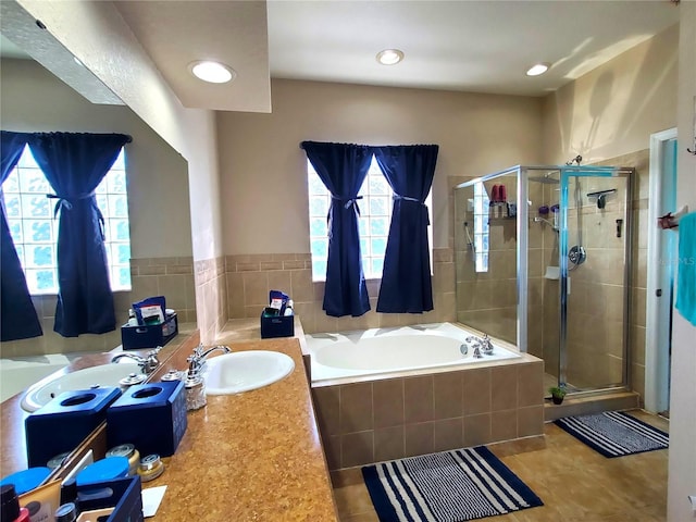 bathroom with tile patterned flooring, plus walk in shower, plenty of natural light, and vanity