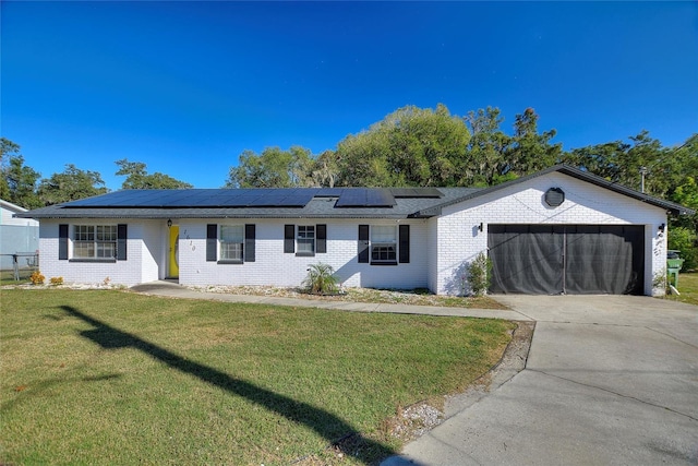 single story home with solar panels, a garage, and a front lawn