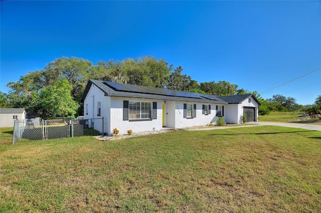 ranch-style house with solar panels, a garage, and a front lawn