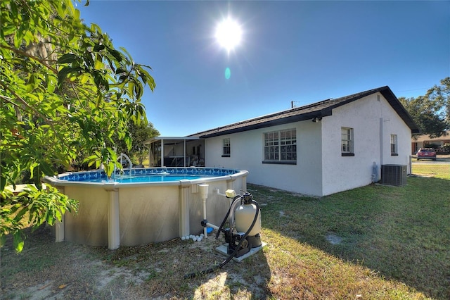 back of house with a sunroom, a yard, and central air condition unit