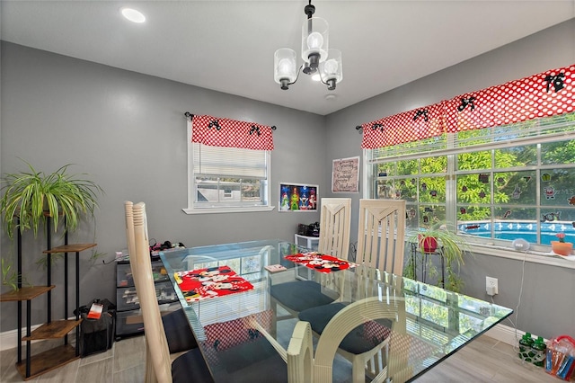 dining space with a notable chandelier and light hardwood / wood-style flooring