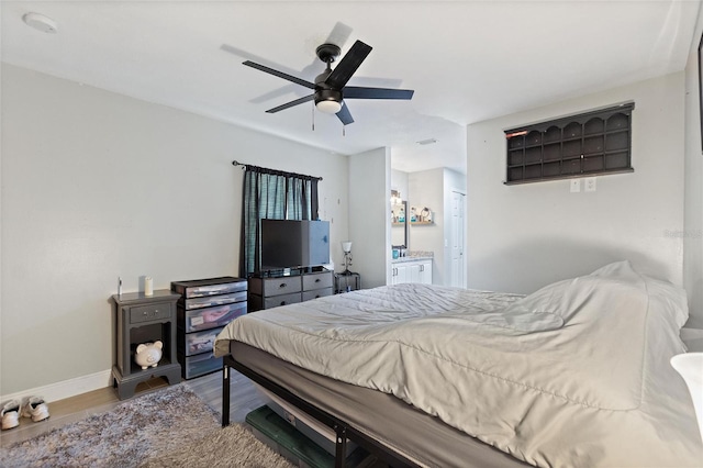 bedroom with hardwood / wood-style floors, connected bathroom, and ceiling fan