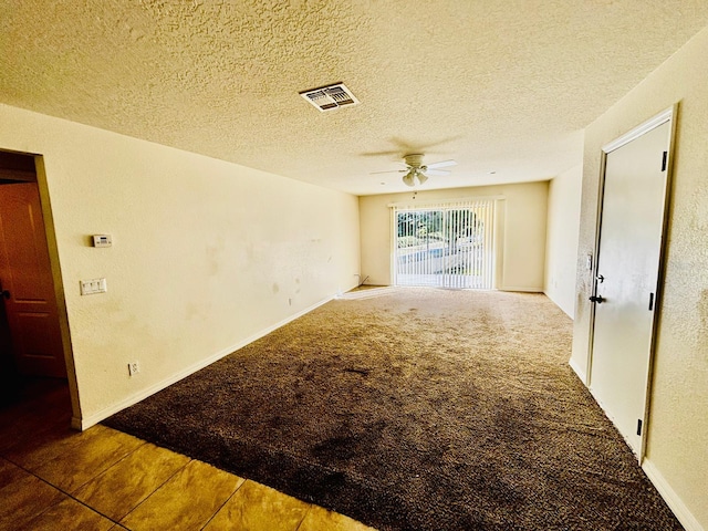 carpeted spare room with ceiling fan and a textured ceiling