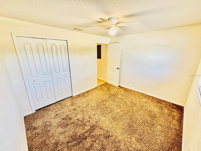 unfurnished bedroom featuring carpet flooring, a textured ceiling, ceiling fan, electric panel, and a closet