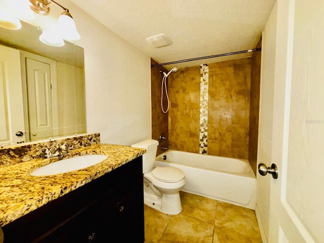 full bathroom featuring vanity, tile patterned floors, tiled shower / bath combo, toilet, and a textured ceiling