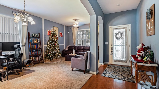 foyer entrance with an inviting chandelier and dark hardwood / wood-style flooring