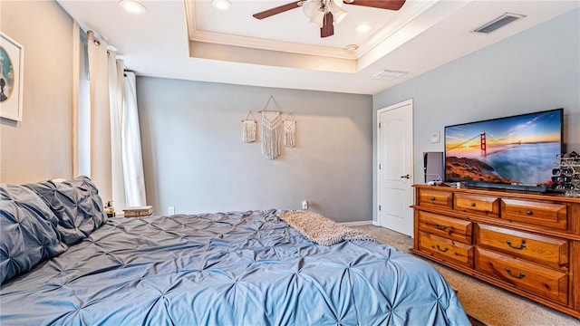 bedroom with a raised ceiling, ornamental molding, carpet, and ceiling fan