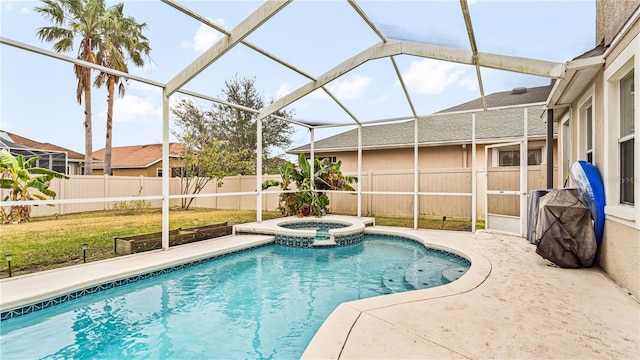 view of pool with an in ground hot tub, a patio area, and glass enclosure